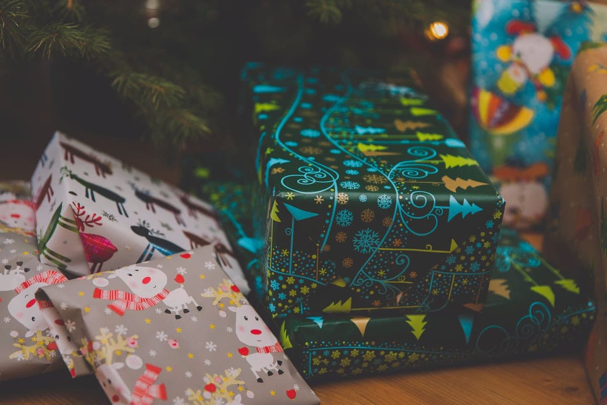 Wrapped presents in colorful paper under a decorated tree